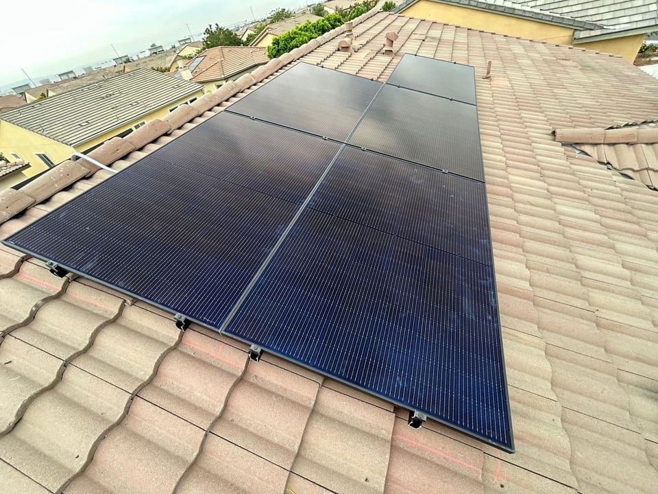 Black solar panel array installed along a tile roof