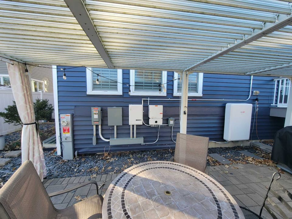 Solar inverter and electrical equipment mounted beside a covered patio