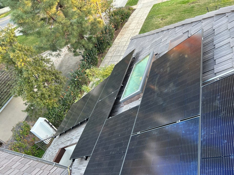 Solar array installed around a skylight, viewed from the rooftop