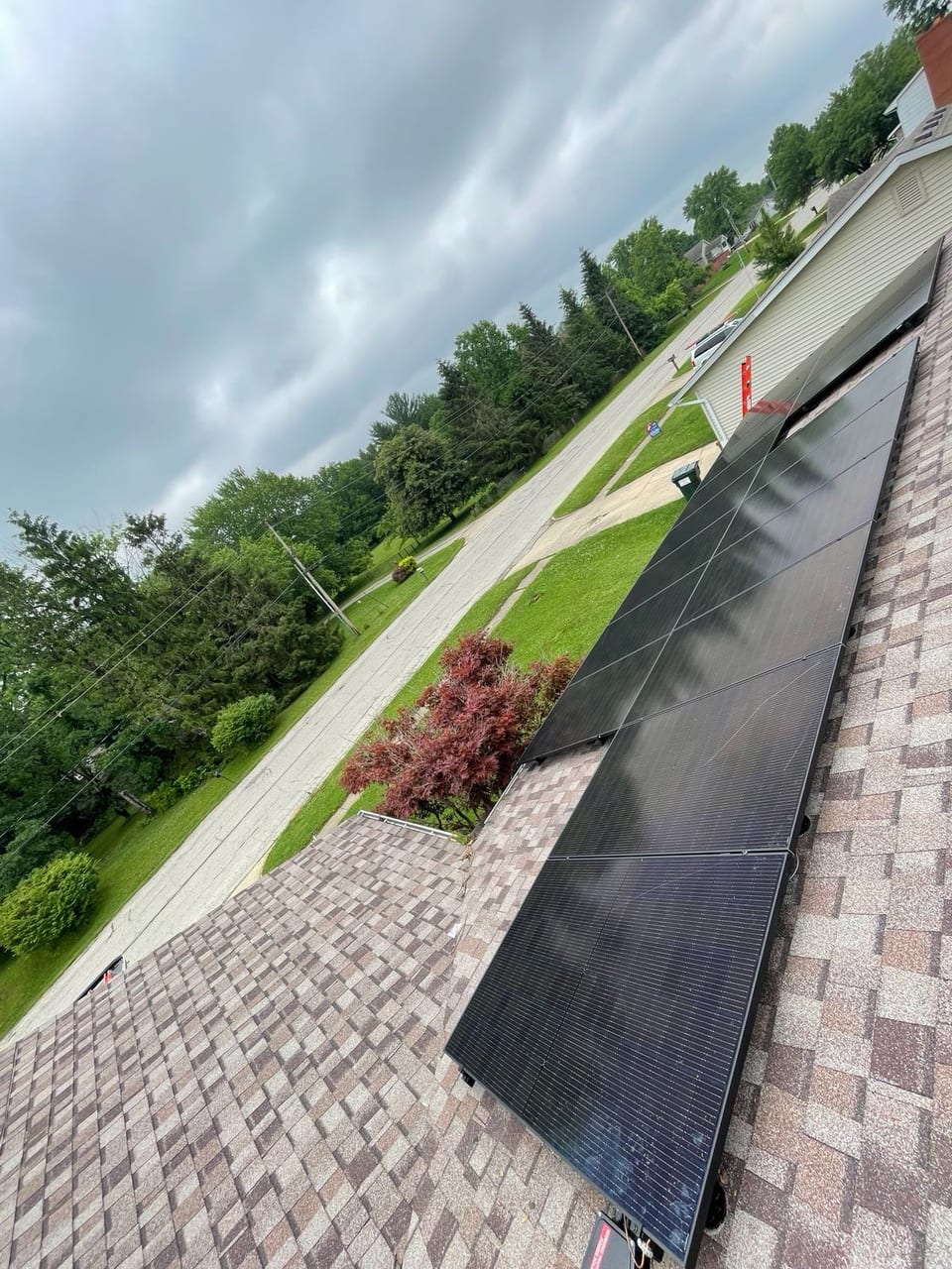 Solar panels on a tile roof above landscaped garden beds