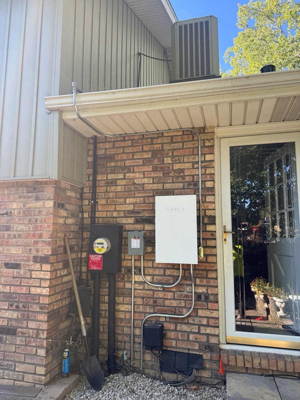 Solar electrical equipment installed beside the entry of a brick home