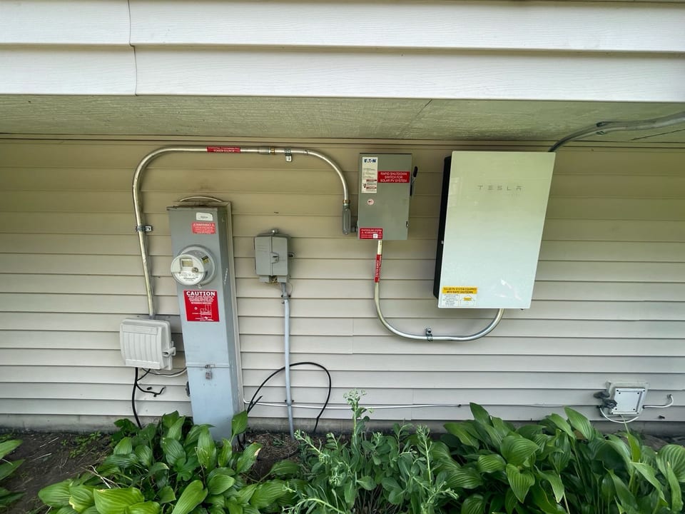 Solar inverter and conduit installed on a home exterior wall