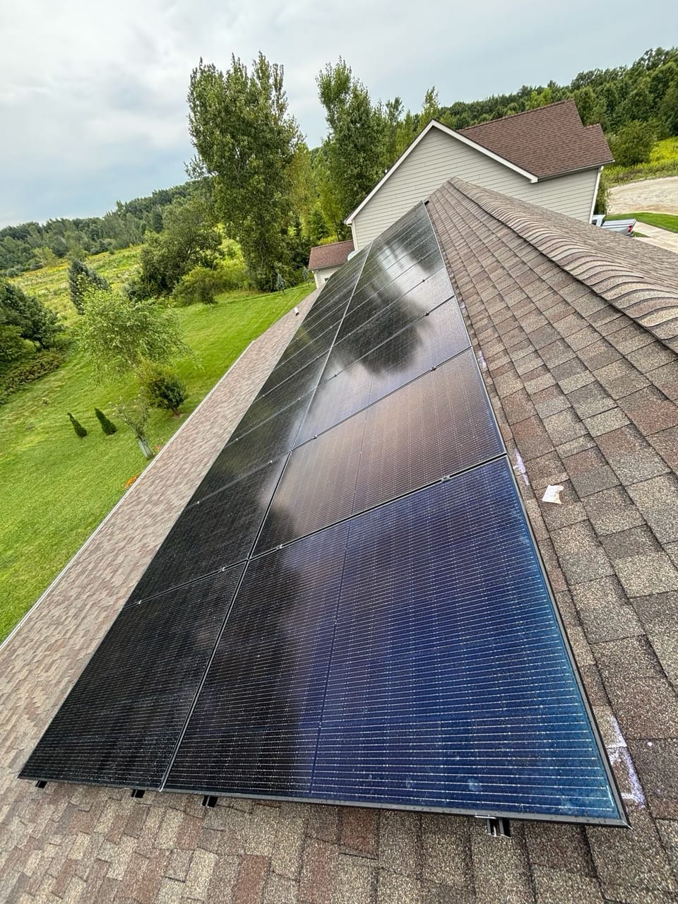 Solar panels along a roof slope with open land beyond
