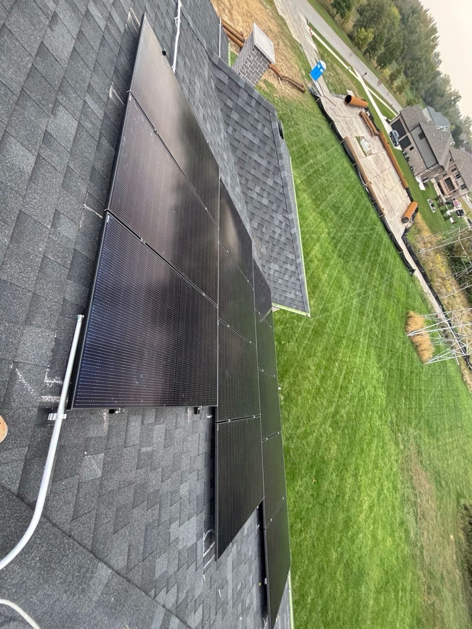 Solar panels along a roof edge above a green lawn