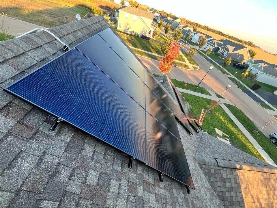 Rooftop solar array at golden hour, overlooking a neighborhood