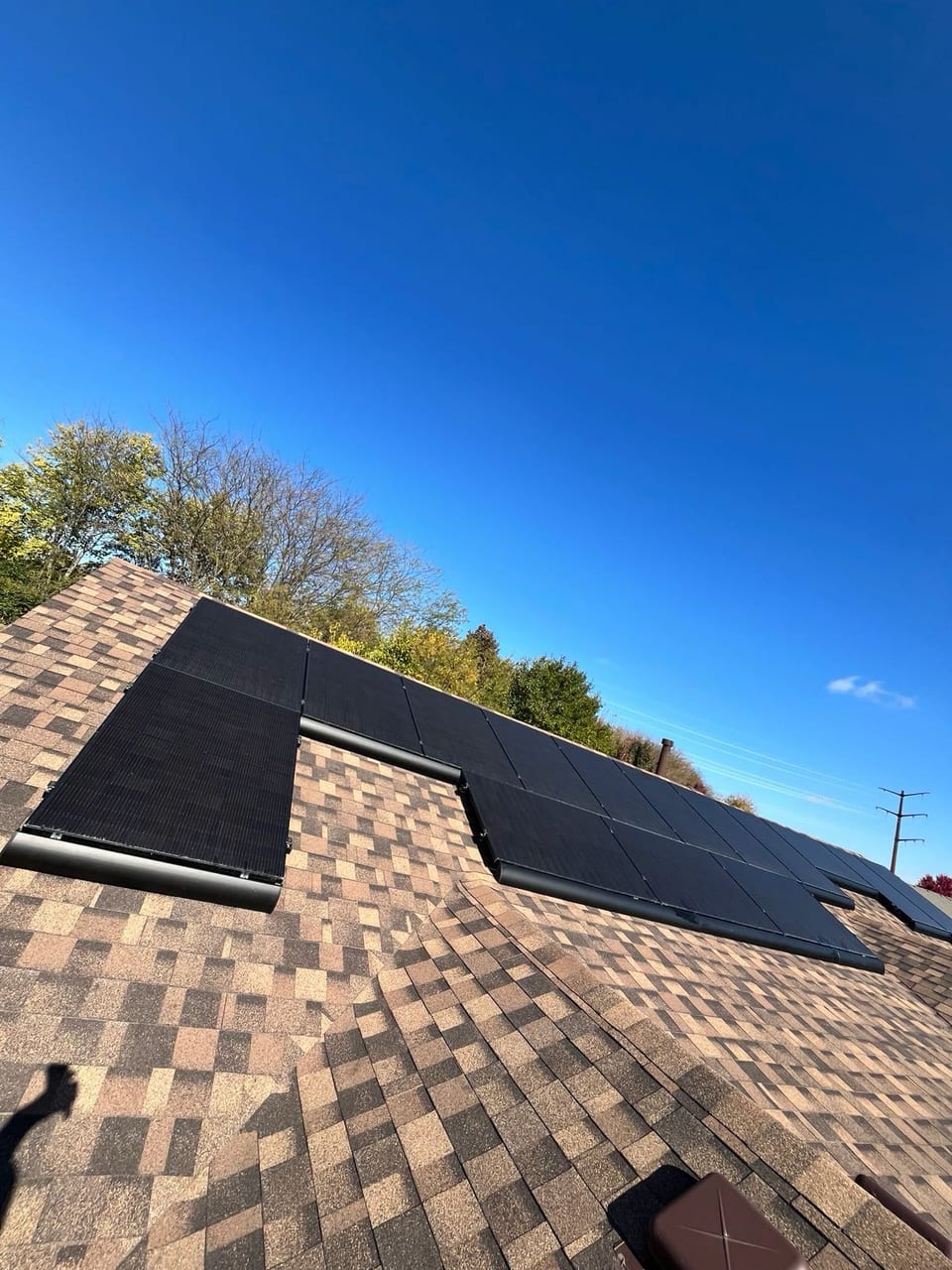Solar panels on a residential roof under a bright blue sky