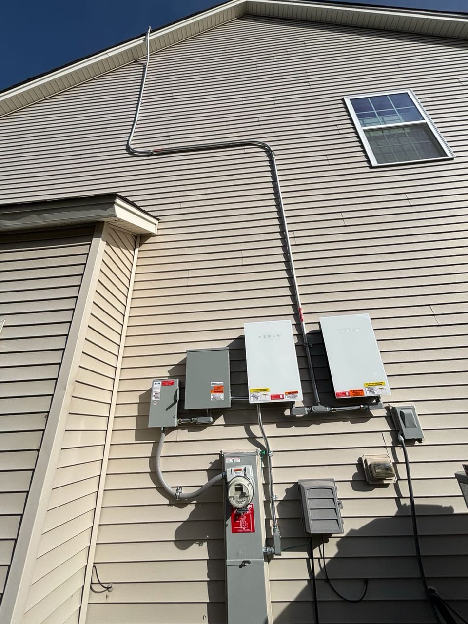 Solar inverters and electrical equipment mounted on a home exterior