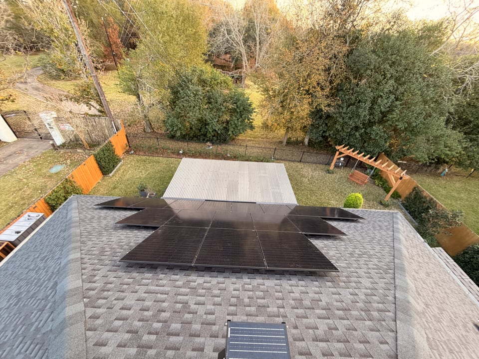 Rooftop solar array overlooking a wooded backyard